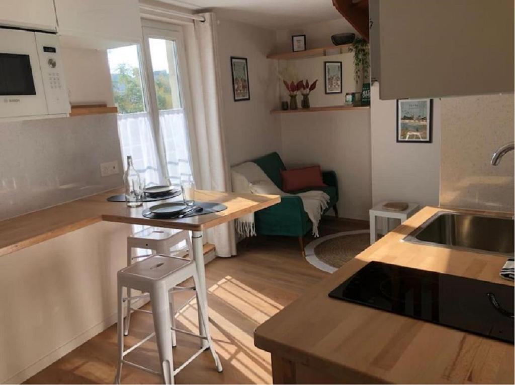 une cuisine et un salon avec une table et un évier dans l'établissement L'appart des Halles Tours centre, à Tours