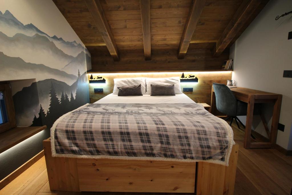 1 dormitorio con cama y escritorio en Lo Mieton - Affitti Brevi Italia, en Champoluc
