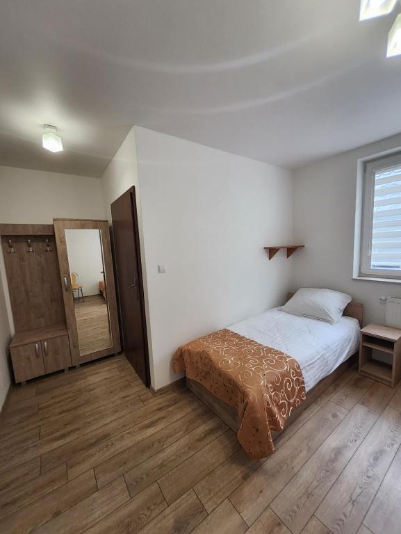 Schlafzimmer mit einem Bett und einem Spiegel in der Unterkunft Hotel Resident in Suchedniów