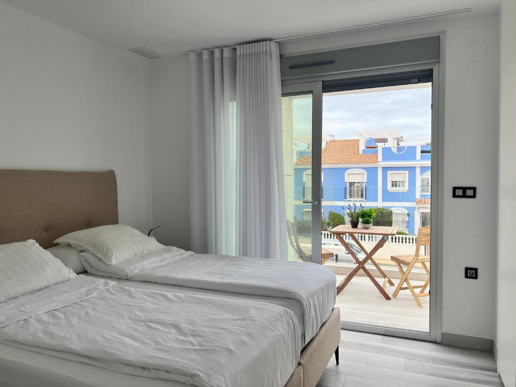 a bedroom with a bed and a view of a balcony at Casa Flore-Lou in Orihuela Costa