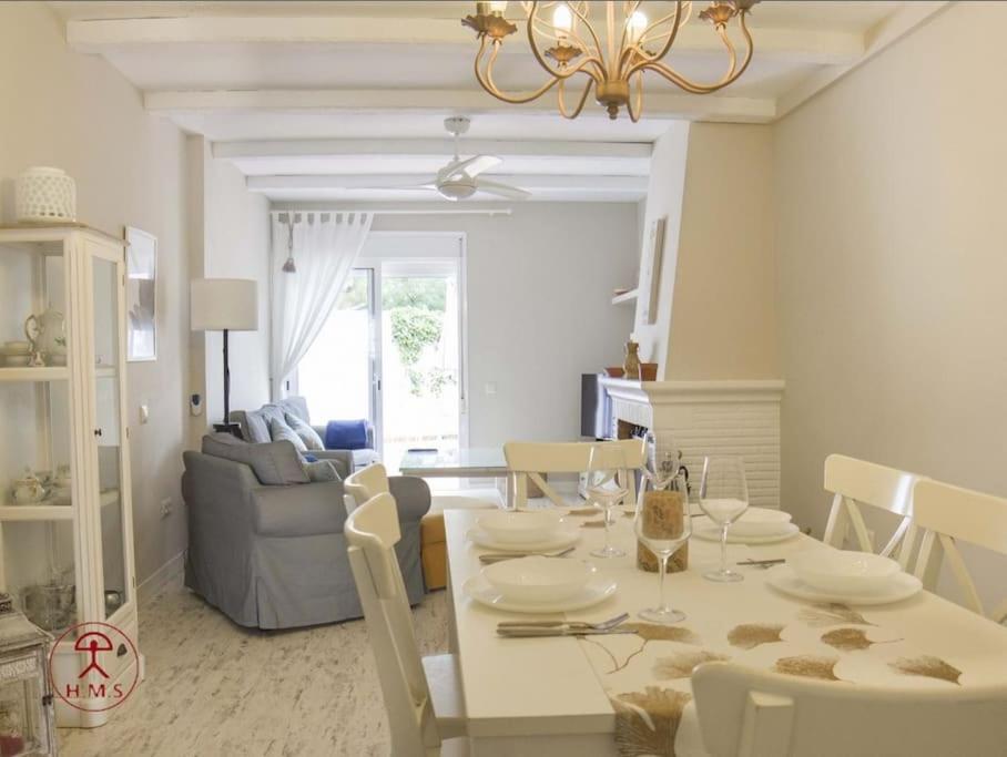 a dining room and living room with a table and chairs at Las Palmeras in San José