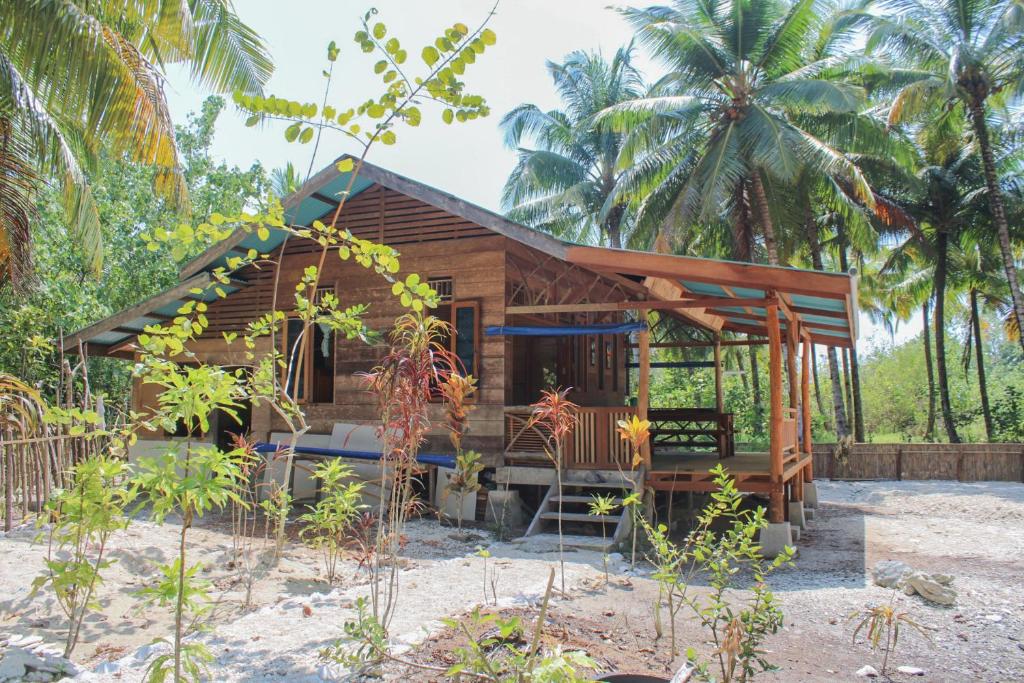 a cabin on the beach with palm trees at Toro Simalatcat Surfcamp in Masokut