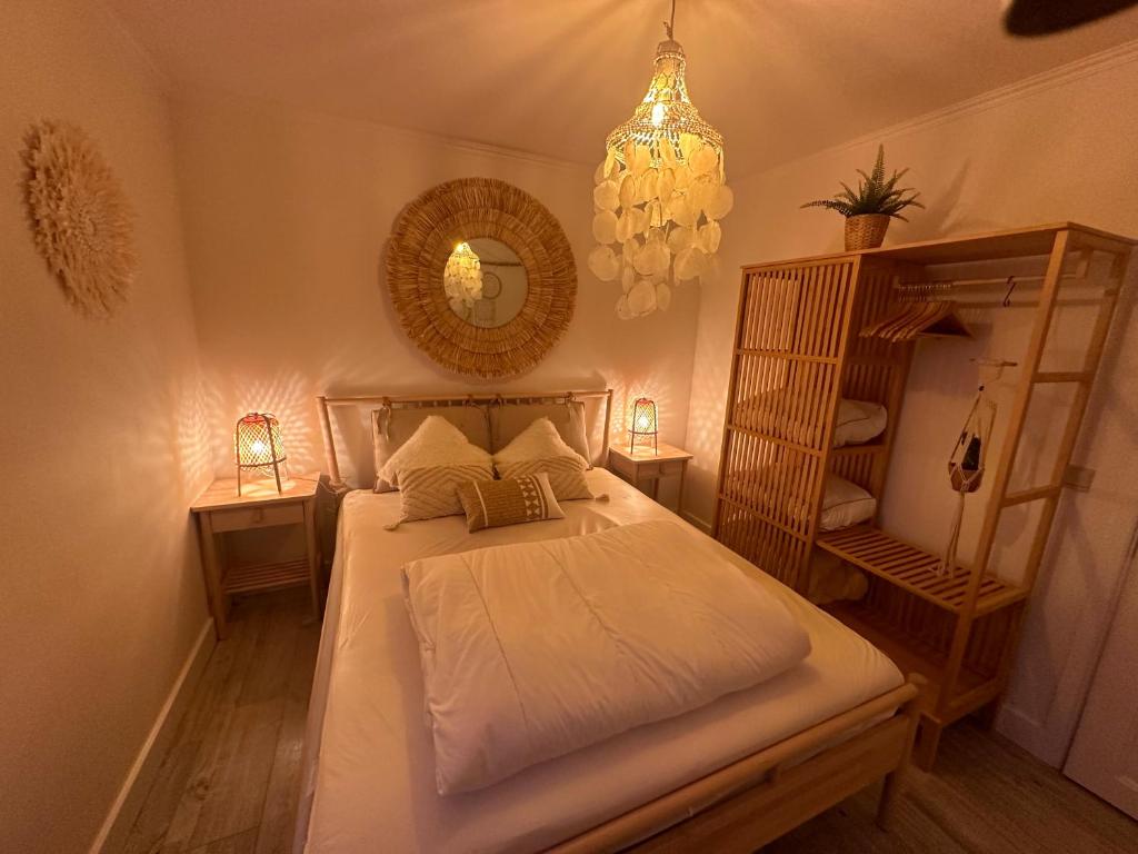 een slaapkamer met een bed met een spiegel en een kroonluchter bij TOP appartement met garage "Au Franelle" in Oostende