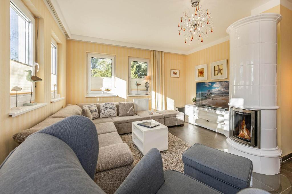 uma sala de estar com um sofá e uma lareira em Inselhaus Heringsdorf EG em Heringsdorf