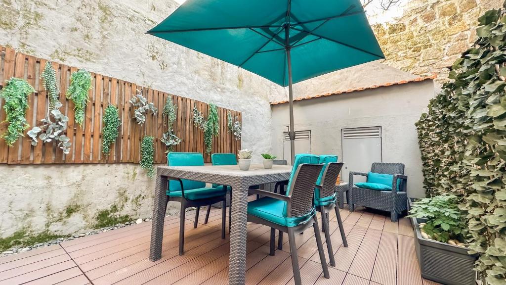 a table with chairs and an umbrella on a patio at Almada Apartments 468 in Porto