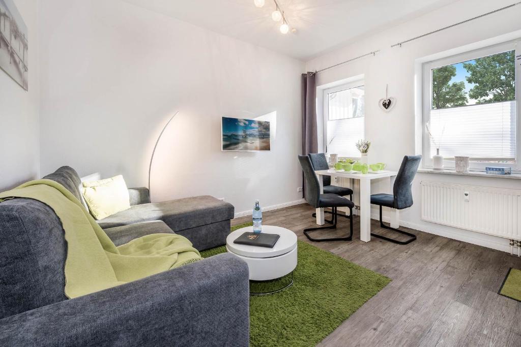 - un salon avec un canapé et une table dans l'établissement Villen am Buchenpark 17, à Heringsdorf