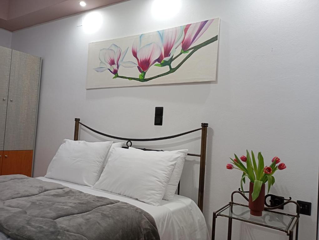 1 dormitorio con 1 cama y una pintura en la pared en VASO'S APPARTMENTS A, en Mesolongi