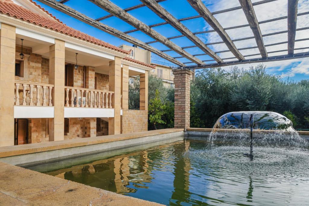 una fontana nel mezzo di una piscina di fronte a un edificio di Archontiko Frideriki Luxury Apartments a Chio (Chios)