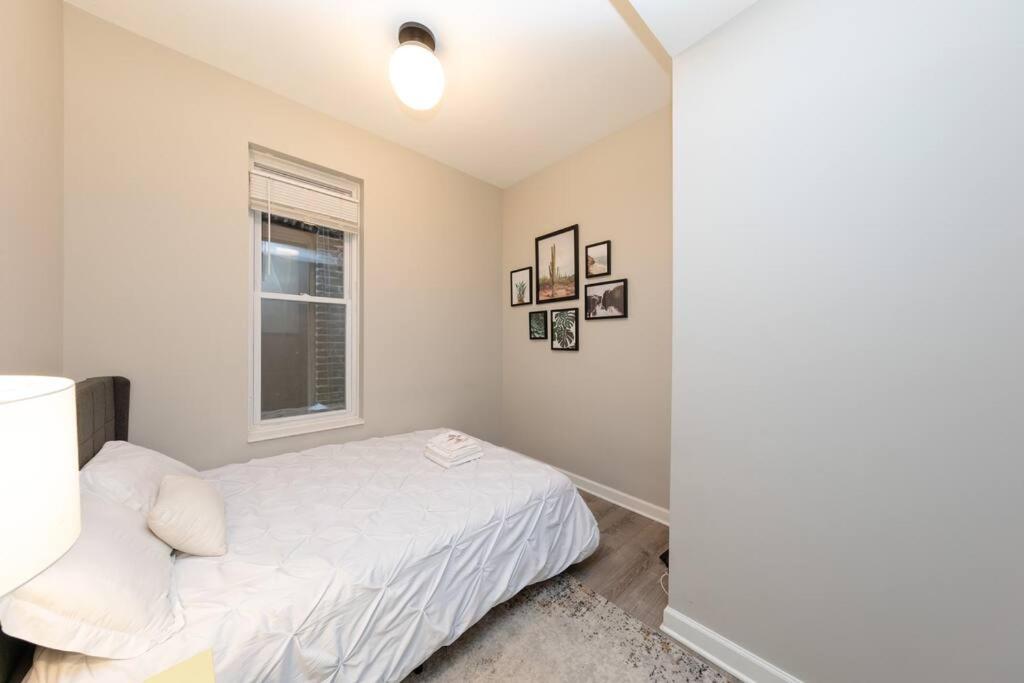 a white bedroom with a bed and a window at The Secret West Loop Oasis in Chicago