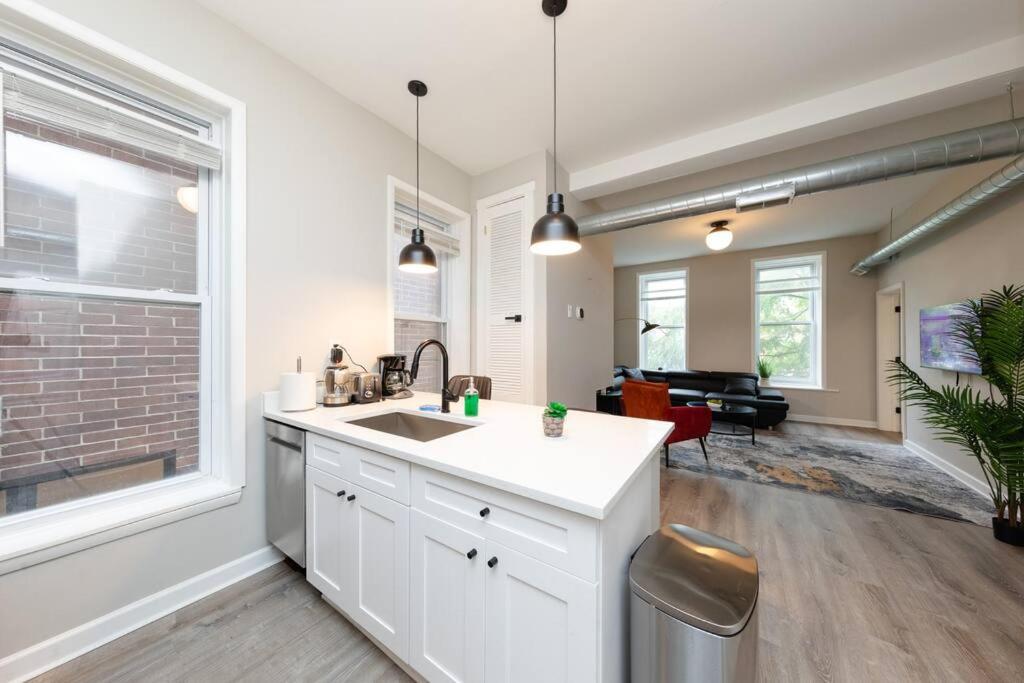 a kitchen with a sink and a living room at The Secret West Loop Oasis in Chicago