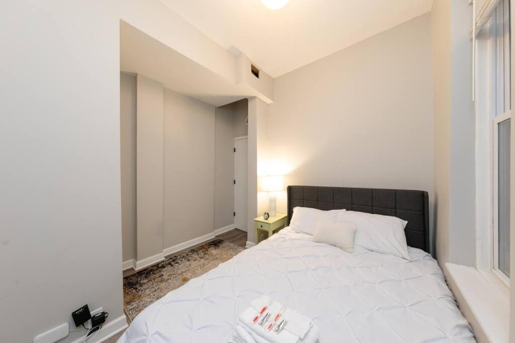 a bedroom with a white bed and a window at The Secret West Loop Oasis in Chicago