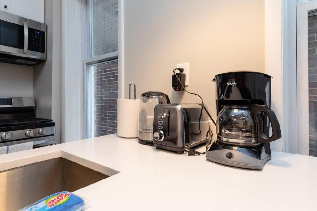 a kitchen counter with appliances on a white counter top at The Secret West Loop Oasis in Chicago