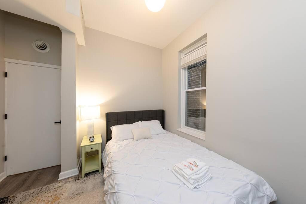 a bedroom with a white bed and a window at The Secret West Loop Oasis in Chicago