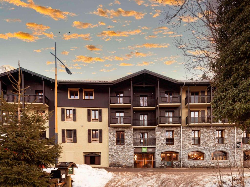 an apartment building with snow in front of it at ibis Styles Les Houches Chamonix in Les Houches