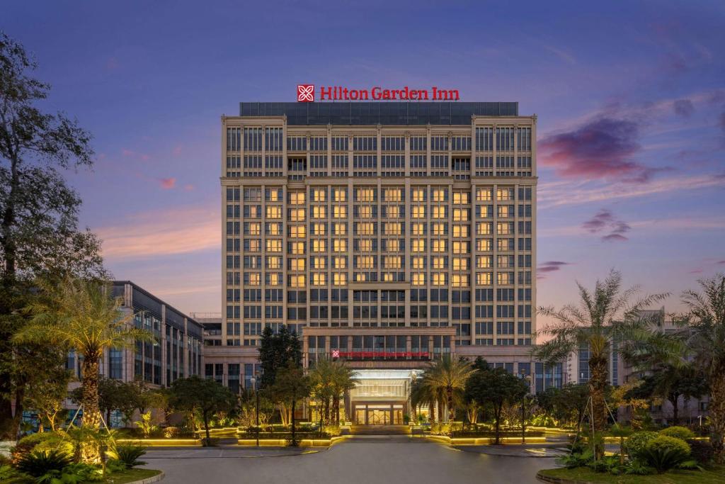 Hilton Garden Inn Jiangmen Xinhui في جيانغمن: مبنى عليه مليون نزل حديقة فوقه