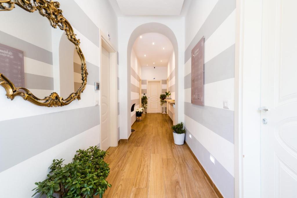 a hallway with white walls and a gold mirror at The Railway 74 in La Spezia