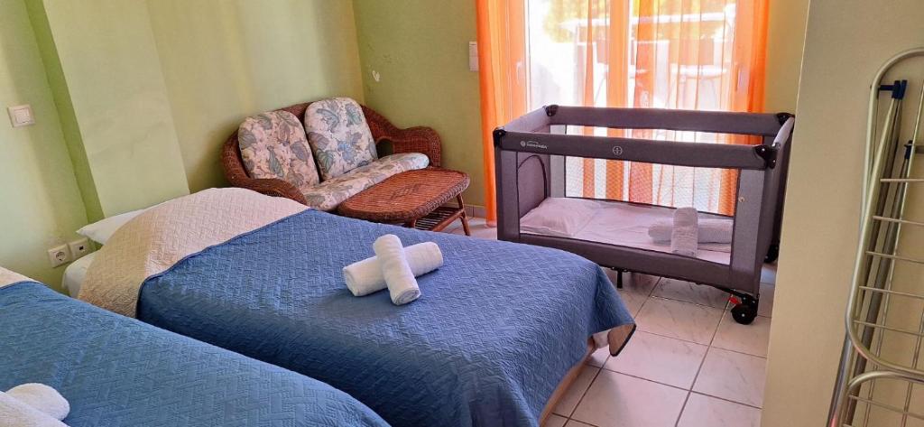 a bedroom with two beds and a baby crib at MARIA'S DREAM HOUSE in Eretria