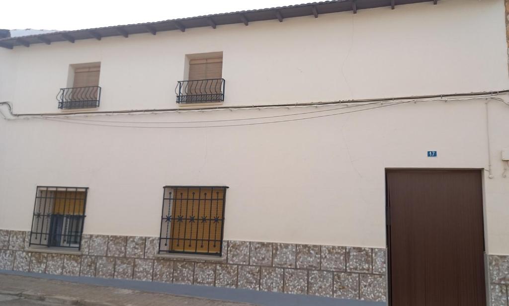um edifício branco com janelas e uma porta em Casa Custodia em Mota del Cuervo