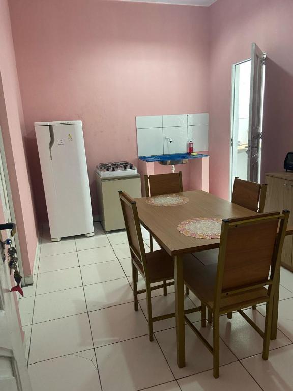 eine Küche mit einem Tisch und Stühlen sowie einem Kühlschrank in der Unterkunft Kit net nova in Ananindeua