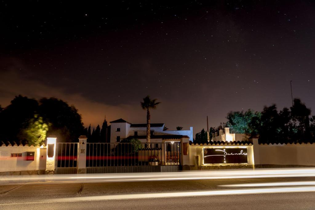 Una imagen nocturna de una valla y una casa. en Finca Duende - Adults Only, en Hozanejos