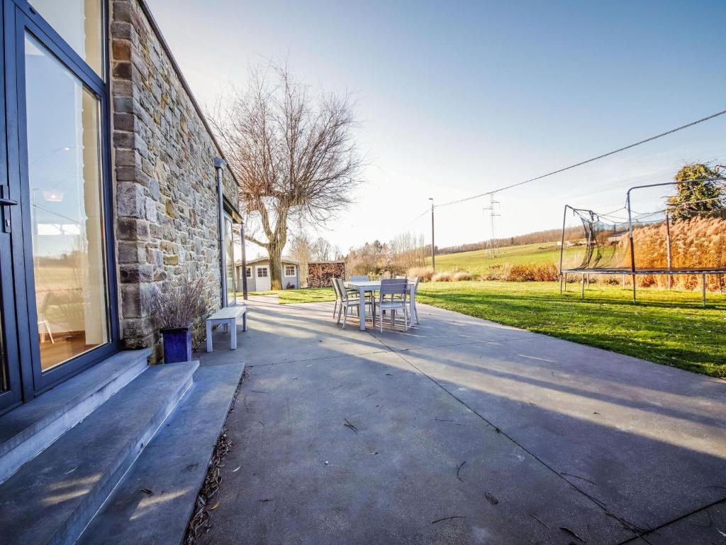 a patio with a table and chairs outside of a building at Maison Le Saint Pierre with lots of charm in Modave