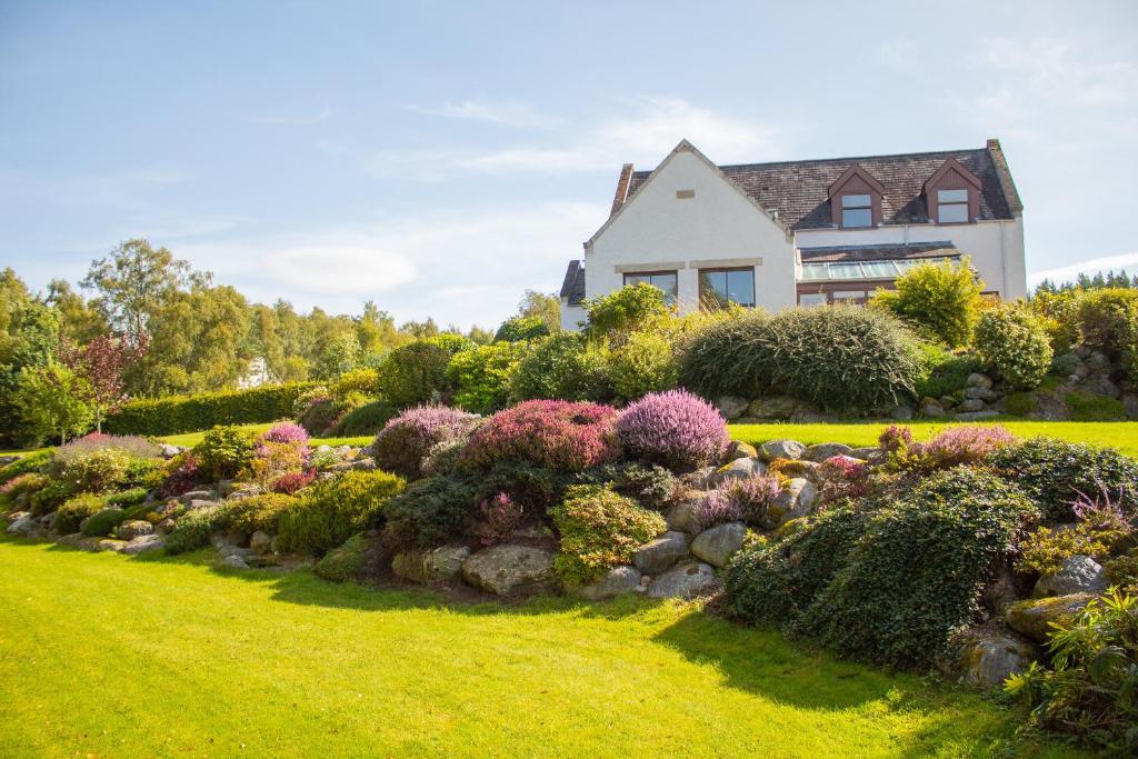 una casa con un jardín delante de ella en Carriden en Insh