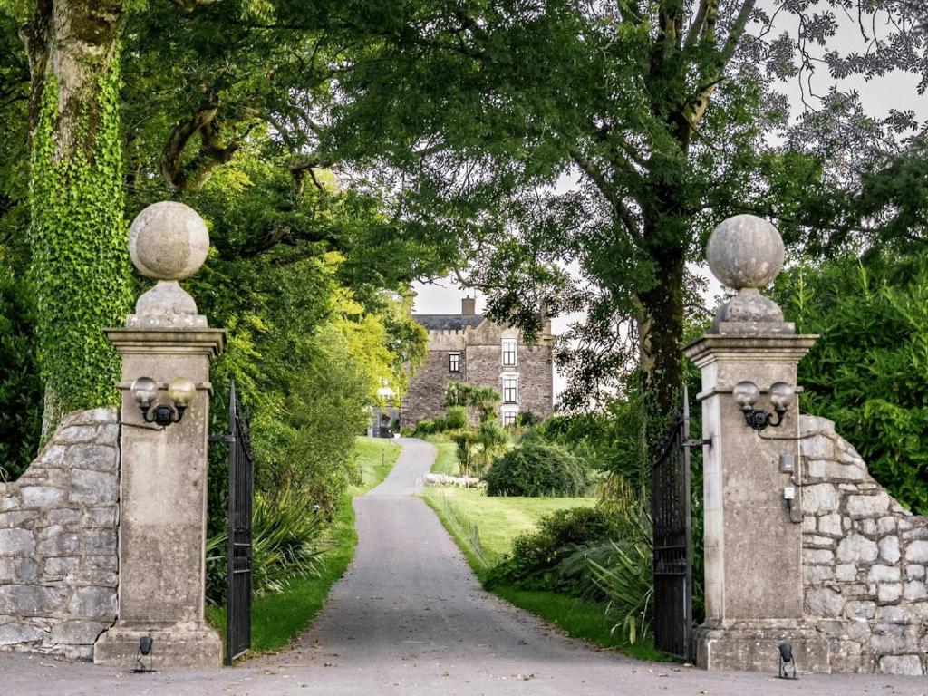 un ingresso a un giardino con arco in pietra di Ballea Castle a Cork