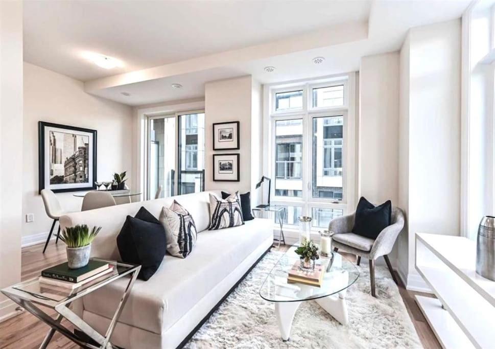 a living room with a white couch and some windows at Luxe Toronto Townhome, Rooftop Terrace, Parking in Toronto