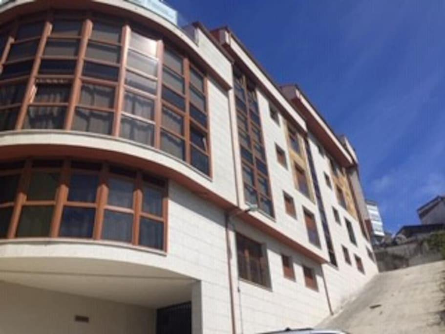 een groot wit gebouw met veel ramen bij Apartamento Camiño dos Faros in Malpica