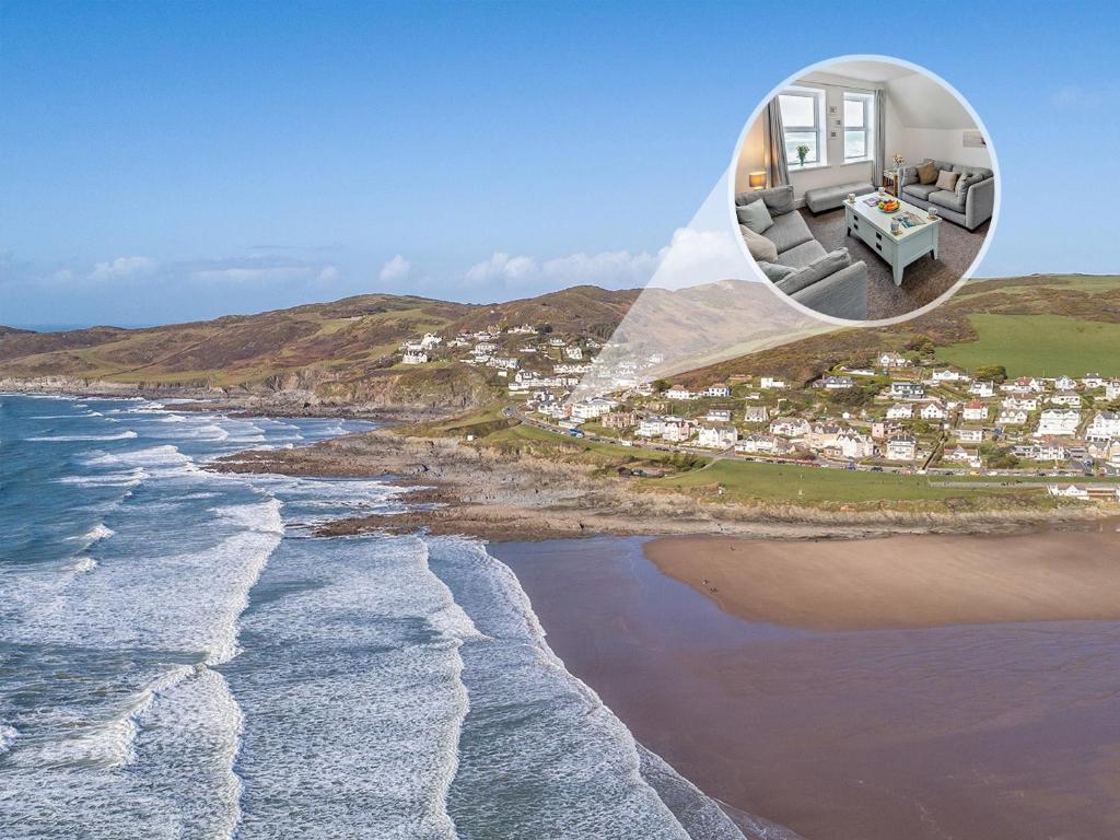 a house on the beach next to the ocean at 2 Bed in Woolacombe 76350 in Woolacombe