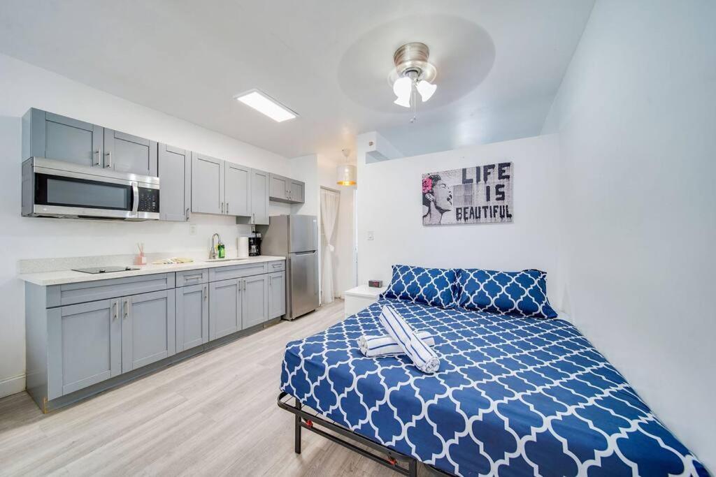 a bedroom with a blue bed and a kitchen at Beachy 1 b/r, w/2 Queen Beds, On Ocean Drive Beach in Miami Beach