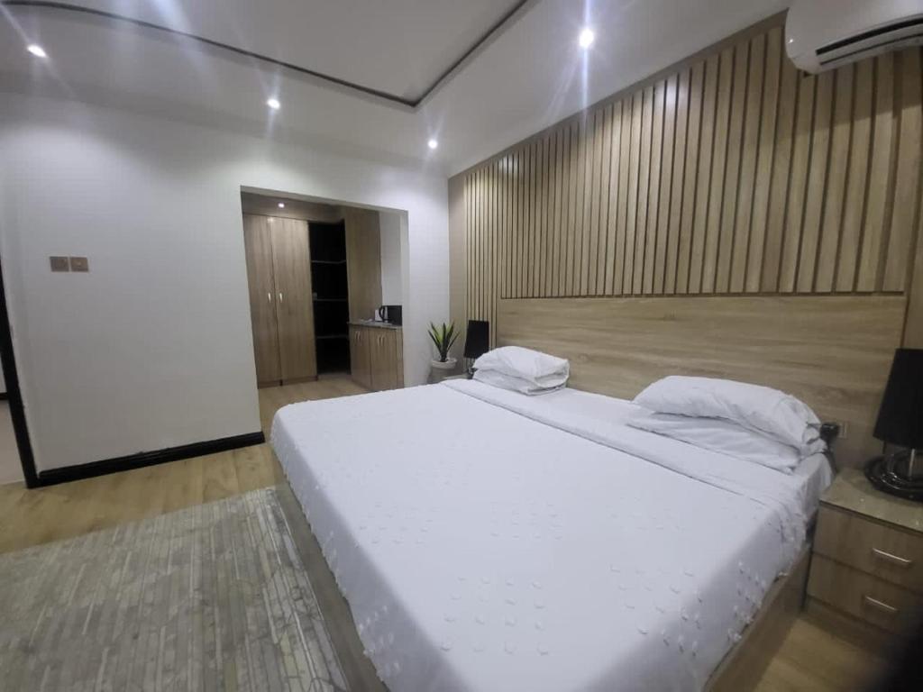 ein Schlafzimmer mit einem großen weißen Bett in einem Zimmer in der Unterkunft Mansal Luxury Apartments in Lagos