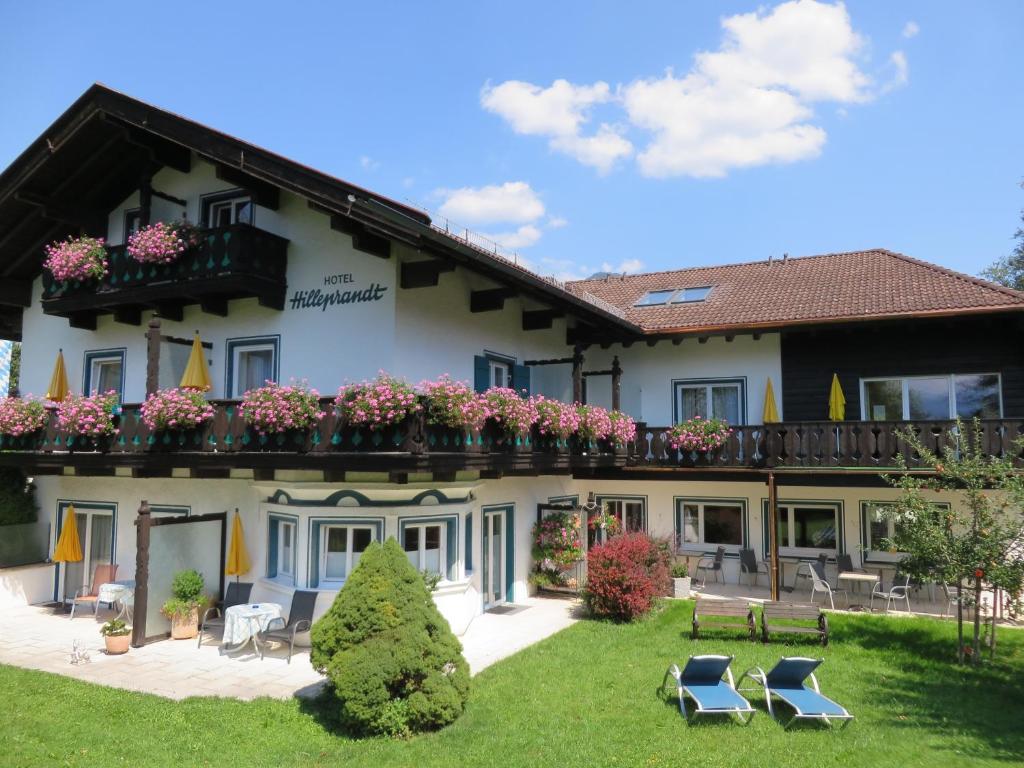 a hotel with chairs and flowers in the yard at Hilleprandt - Adults Only in Garmisch-Partenkirchen