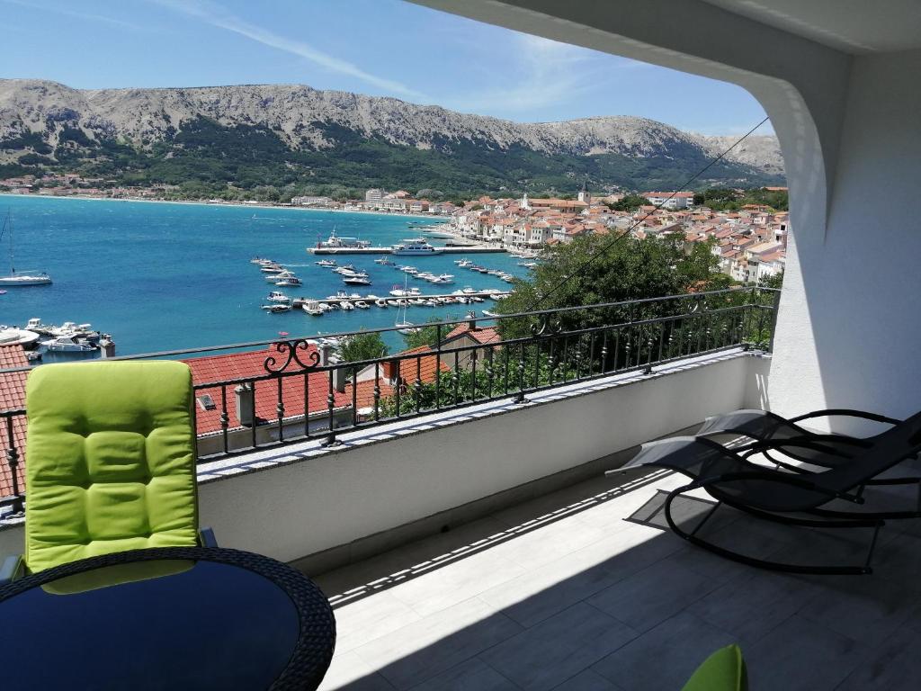 a balcony with chairs and a view of a harbor at Apartments Andrea in Baška
