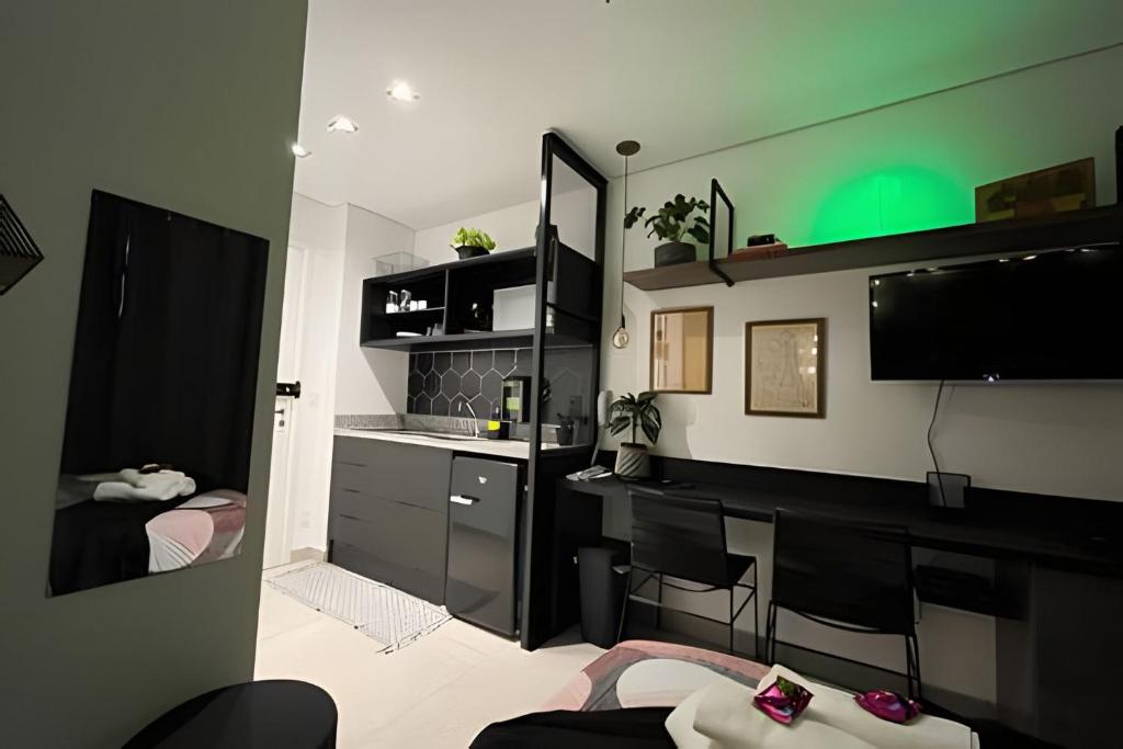 Habitación con 1 dormitorio con escritorio y espejo. en Studio próximo ao teatro Renault e hospitais, en São Paulo