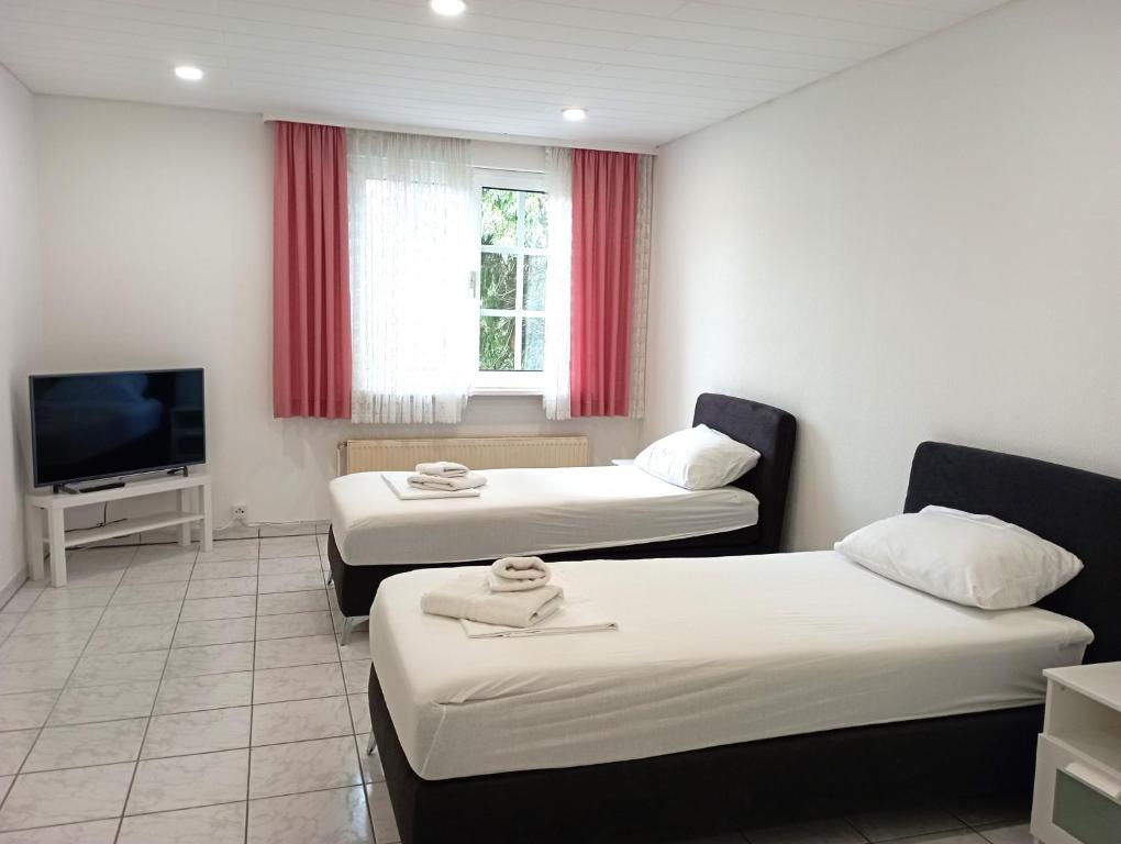 a room with two beds and a flat screen tv at Monteurwohnung Renate in Saarbrücken