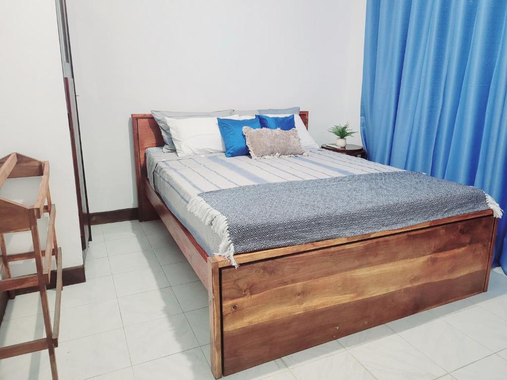 a bed in a room with a blue curtain at Traveller's casa closer to highway in Homagama