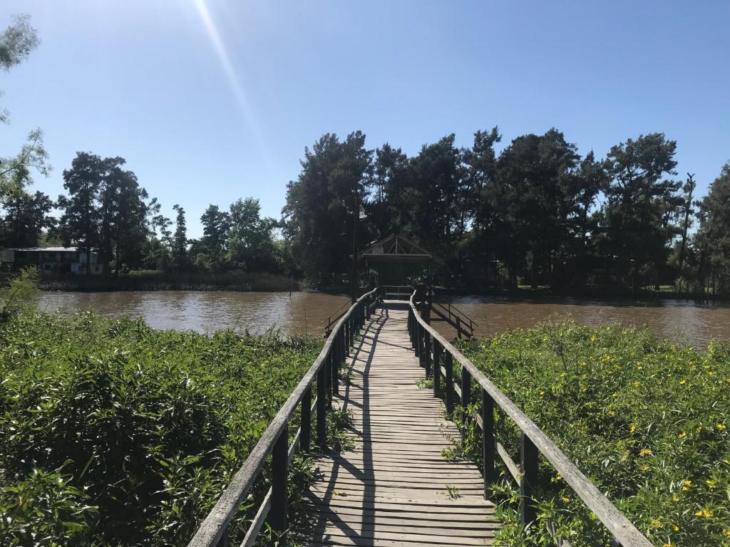 eine Holzbrücke über einen Fluss mit Wasser in der Unterkunft Isla Curubica in Tigre