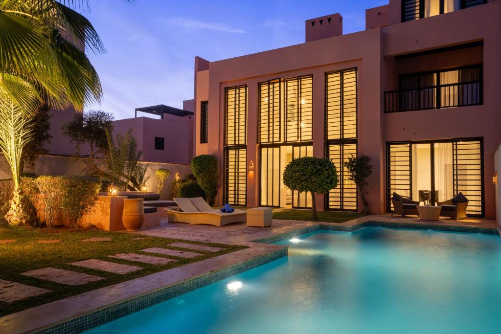 a house with a swimming pool in front of a house at Al Maaden Villa Hotel & Spa in Marrakesh