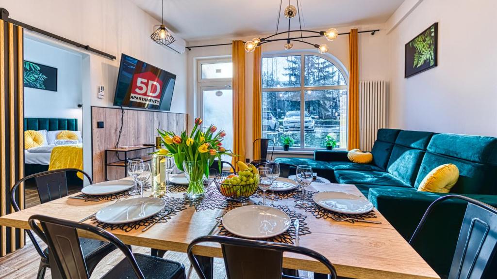 a dining room with a table and a couch at Apartament Luxury 3 sypialnie, Sauna i Klimatyzacja - 5D Apartamenty in Świeradów-Zdrój