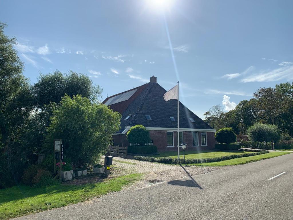 une maison arborant un drapeau sur le côté de la route dans l'établissement Bed and Breakfast de Salix, à Hitzum