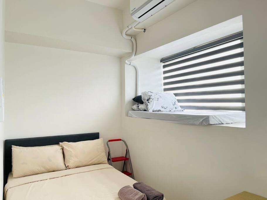 una piccola camera da letto con un letto e una finestra di * * WV 2 Tranquil Haven a Città di Iloilo