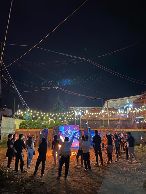 un gruppo di persone che ballano di notte con le luci di MỘC CHÂU HOUSE a Mộc Châu