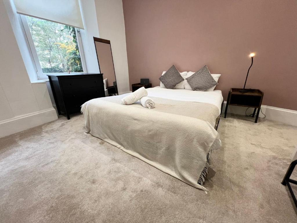 1 dormitorio con 2 camas y ventana en Cosy Glasgow Retreat with Modern Amenities, en Glasgow
