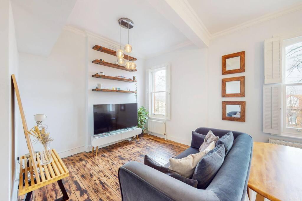 a living room with a couch and a television at Modern 1BD flat in Clapham Old Town in London