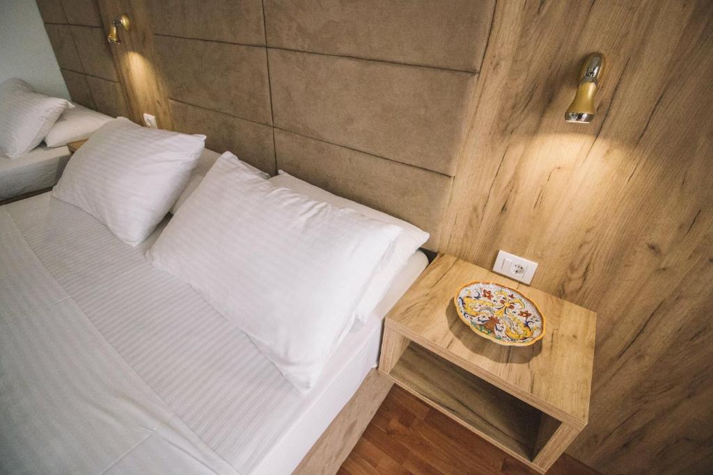 um quarto com uma cama e uma mesa com um prato em Mona em Ulcinj