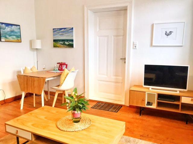 een woonkamer met een tafel en een televisie en een eetkamer bij Ferienwohnung Schönwälder 