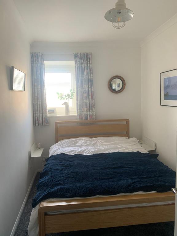 sypialnia z łóżkiem z niebieskim kocem w obiekcie Cosy room 10 min from beach w Brighton and Hove