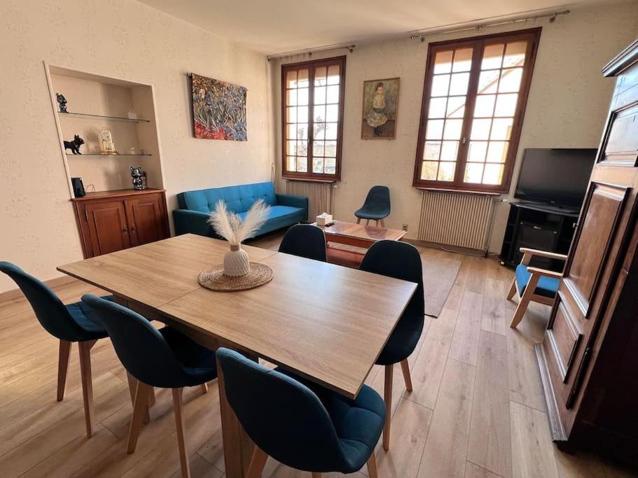 uma sala de estar com uma mesa de madeira e cadeiras em Maison au pied des Vignes em Vosne-Romanée
