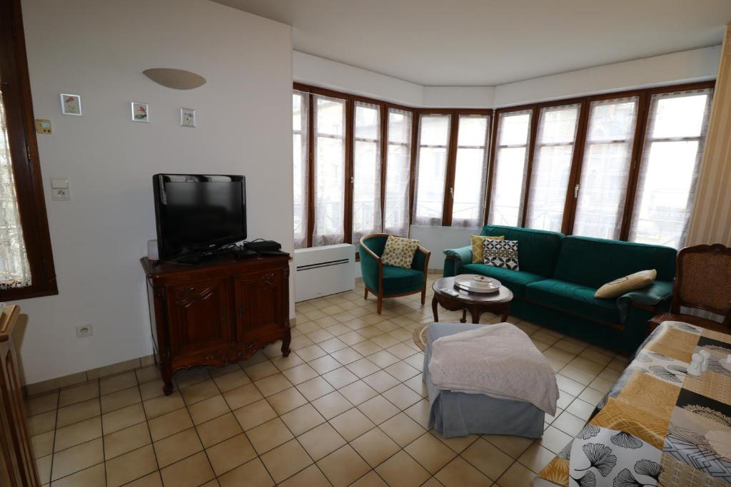 a living room with a couch and a tv at Idéal , Plein centre-ville tout confort in Espalion